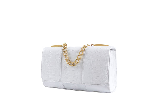 Side front view Belinda white ostrich shin top flap clutch bag from the Adele Exclusive Luxury Design Handbag Collection with top chain handle and decorative hardware, 24 carat gold plated. Chain and leather detachable shoulder strap. Inside back zipper pocket and front inside patch pocket. High quality suede leather interior and hidden magnetic lock closure.
