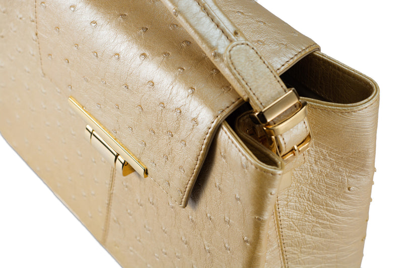 Ostrich leather constructed top flap handbag with an Italian lift lock closure. Inside zipper pocket, leather suede interior. Top handle 24 carat gold plated hardware,detachable shoulder strap with adjustable buckle. Bottom feet studs.