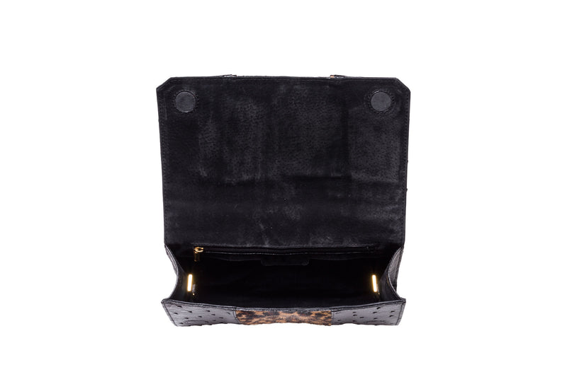 Adele Exclusive Luxury Design Open top view top flap clutch bag. Black ostrich and printed hair on hide clutch with gold leather trim. Top chain handle in 24 carat gold plated decorative hardware. Detachable shoulder strap from chain and leather. Inside back zipper pocket and pocket. Suede leather lining and hidden magnetic lock