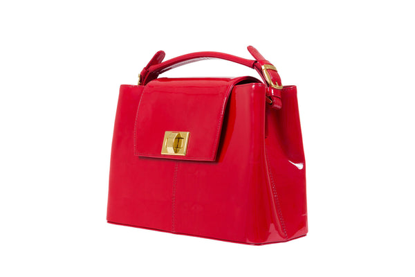 Front side view patent leather bag constructed fold over flap with turn lock closure. Adjustable handles decorated with a buckle and gold hardware. Internal zip pocket, two internal patch pockets and a zipper middle pocket. Detachable shoulder strap. High quality red suede leather interior. Bag feet studs.