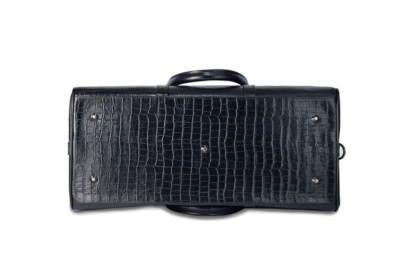 Bottom view Chris Embossed Crocodile Leather duffel bag. Double zipper and double carry handle, gun metal hardware. Adjustable detachable shoulder strap. Black suede leather interior, inside zip pocket and two open pockets.