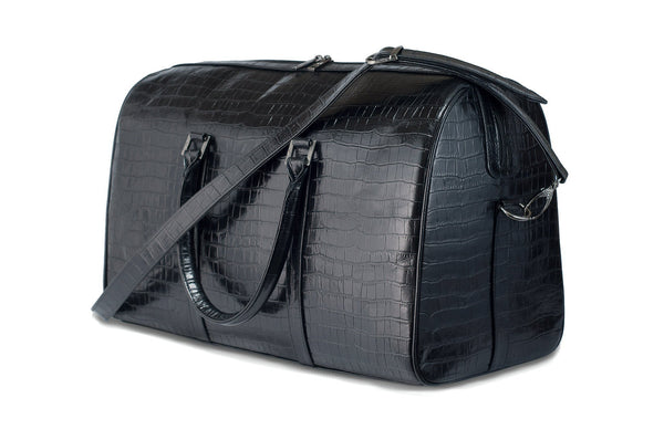 Front side view Chris Embossed Crocodile Leather duffel bag. Double zipper and double carry handle, gun metal hardware. Adjustable detachable shoulder strap. Black suede leather interior, inside zip pocket and two open pockets.