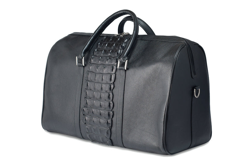 Side front view black bovine leather duffel bag crocodile tail insert. Double zipper, double carry handle, nickel hardware. Adjustable detachable shoulder strap. Black cotton twill interior, inside zip pocket, two open pockets.