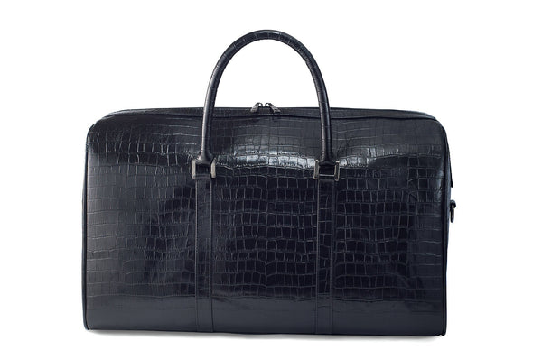 Front view Chris Embossed Crocodile Leather duffel bag. Double zipper and double carry handle, gun metal hardware. Adjustable detachable shoulder strap. Black suede leather interior, inside zip pocket and two open pockets.