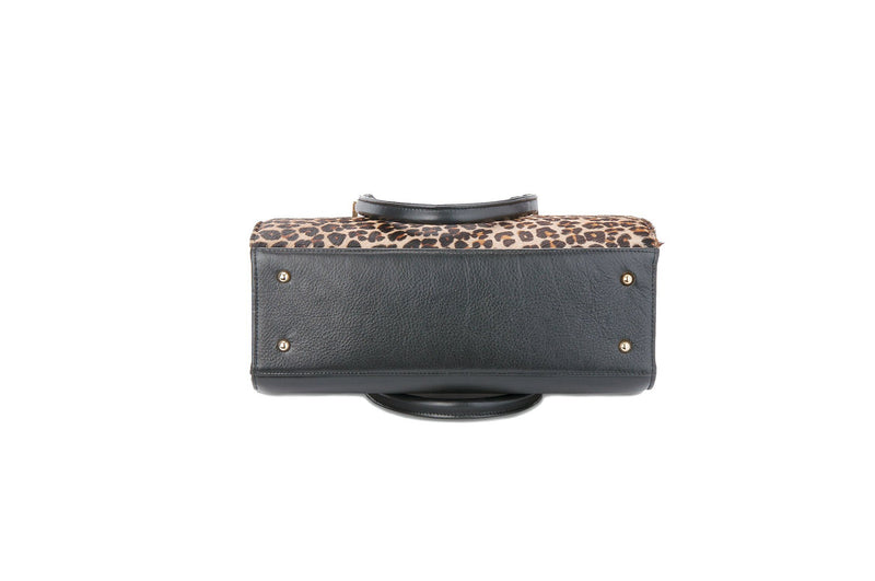 Bottom view Beverley. Black bovine leather side, back and bottom, with leopard printed hair on hide on the front panel. Contains an inside zipper with a back zip pocket. Bag interior consist of black high quality cotton lining. Top zip closure with gold plated fittings. Comes with a detachable shoulder strap with an adjustable buckle. Bottom panel features bag feet studs.