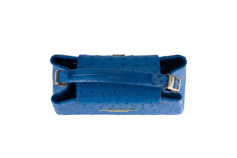 Top view ostrich leather constructed top flap handbag with an Italian lift lock closure. Inside zipper pocket, leather suede interior. Top handle 24 carat gold plated hardware,detachable shoulder strap with adjustable buckle. Bottom feet studs.