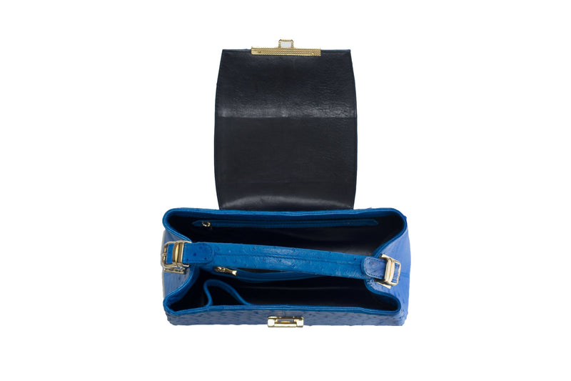 Open top view ostrich leather constructed top flap handbag with an Italian lift lock closure. Inside zipper pocket, leather suede interior. Top handle 24 carat gold plated hardware,detachable shoulder strap with adjustable buckle. Bottom feet studs.