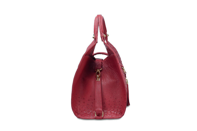 Side view Kimberley red ostrich Leather bag with fold over magnetic strap with D-ring & tassel decoration. Attached round shaped handles decorated with a studs. 
