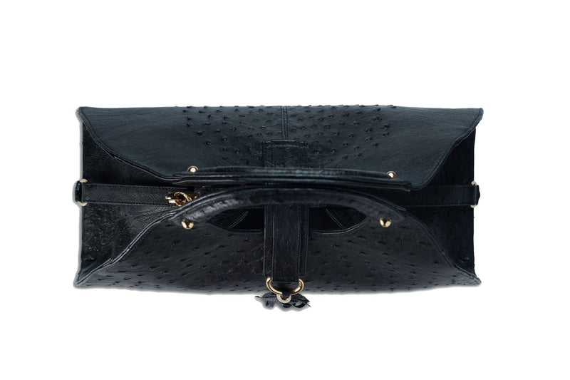 Top view Kimberley black ostrich Leather bag with fold over strap. Hidden magnet with D-ring & tassel decoration for closure. Attached round shaped handles decorated with a studs. Top snap hook closure internal zip pocket with two internal patch pockets. Black high quality suede leather lining, bag feet.