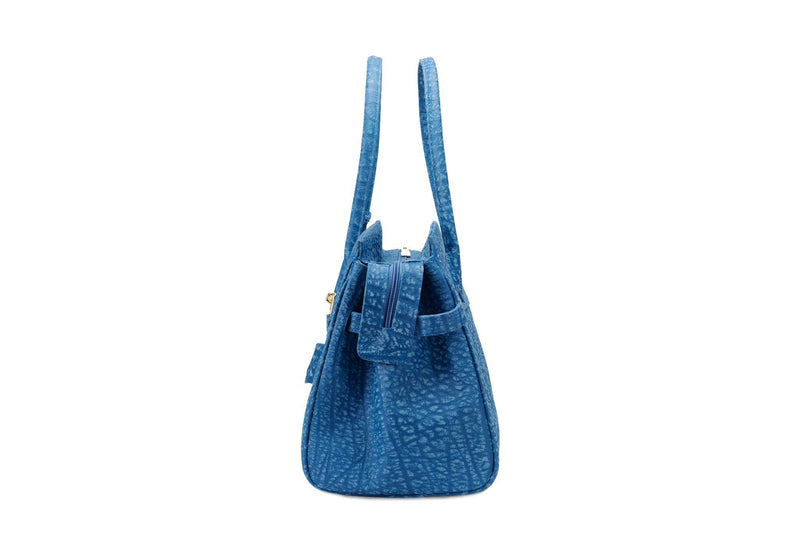 Side view Ripple buffalo blue leather handbag with top zip. The interior contains an inside zip pocket with two internal patch pockets, and is lined with high quality black suede leather. Features a double handle and a gold lock system as decorative hardware. Bag feet studs are located on the bottom panel of the bag.