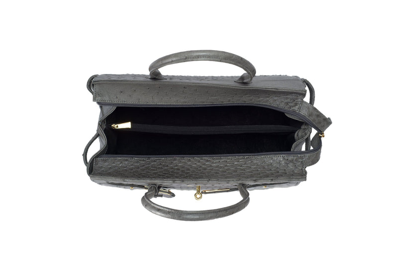 Ostrich leather bag with top zip. The interior contains an inside zip pocket with two internal patch pockets, and is lined with high quality black suede leather. Features a double handle and a gold lock system as decorative hardware. Bag feet studs are located on the bottom panel of the bag.
