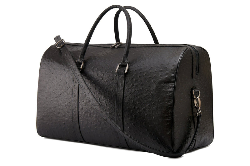 Side front view. Chris Leather duffel bag. Double zipper and an attached double carry handle. Adjustable and detachable shoulder strap. Black suede lines the bag interior. Inside zip pocket and two open pockets.
